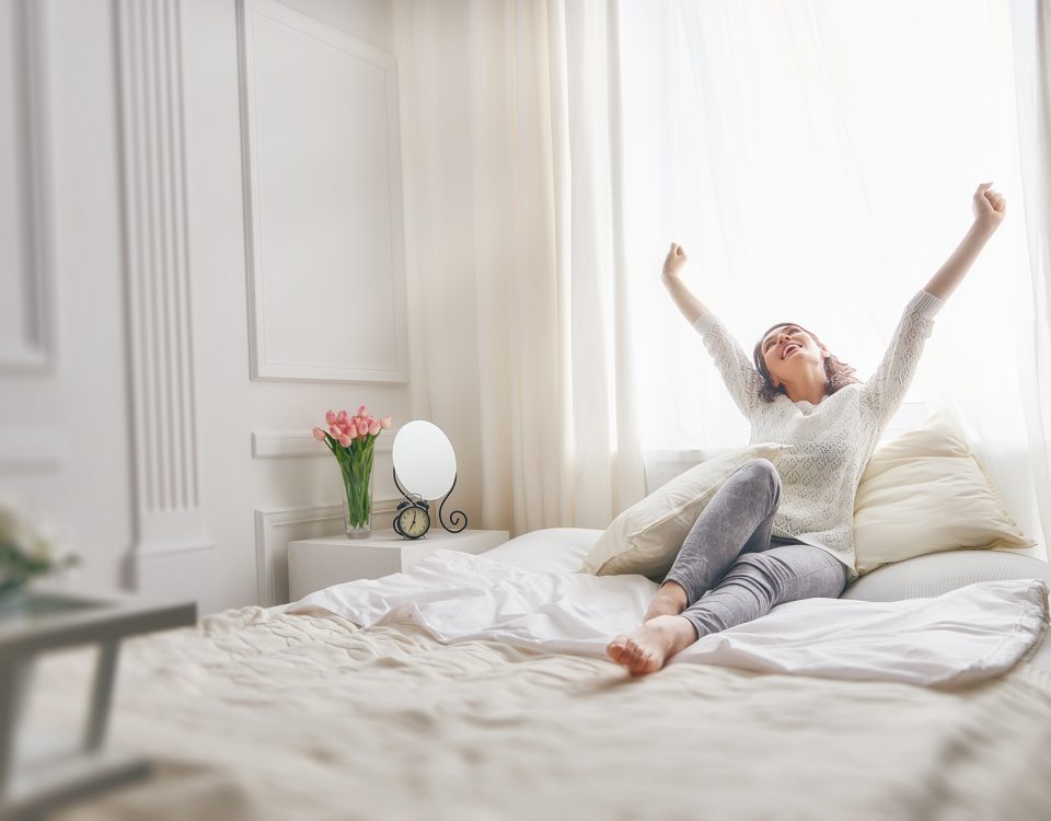 Image d’une femme qui s’étire sur son lit, moment de bien-être pour illustrer l’importance du capital santé»