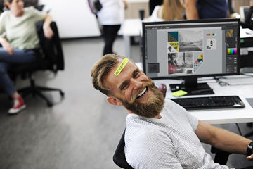 un homme souriant avec post it sur le front pour rester positif à son travail - neurofeedback potentiel motivation